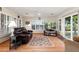 Bright living room with wood floors, white shutters, and a comfortable leather couch perfect for relaxing at 18018 N Highwood Ct, Sun City, AZ 85373