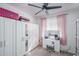 Bright bedroom featuring a ceiling fan, carpeted floor, closet, vanity and a window with pink curtains at 18250 N Cave Creek Rd # 164, Phoenix, AZ 85032