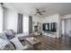 Contemporary living room with a gray sofa, ceiling fan, large mirror, stylish decor, and modern entertainment center at 18250 N Cave Creek Rd # 164, Phoenix, AZ 85032