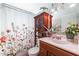 Cozy bathroom with a decorative floral shower curtain and matching sink and wood cabinet at 18435 N 36Th Ave, Glendale, AZ 85308