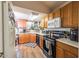 Functional kitchen with oak cabinets, white countertops, stainless steel appliances, and wood-look tile flooring at 18435 N 36Th Ave, Glendale, AZ 85308