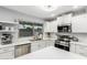 Modern kitchen featuring stainless steel appliances, white cabinetry, quartz counters, and a backyard view at 1847 W Isleta Ave, Mesa, AZ 85202