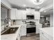 Modern kitchen featuring stainless steel appliances, white cabinetry, and an undermount sink overlooking backyard at 1847 W Isleta Ave, Mesa, AZ 85202