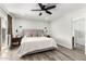 Bright bedroom featuring wood-look floors, a ceiling fan, access to the backyard, and a view of the bathroom at 1847 W Isleta Ave, Mesa, AZ 85202