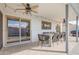 Covered patio area with travertine tile, ceiling fans, and a dining set overlooking the pool at 1847 W Isleta Ave, Mesa, AZ 85202