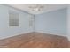 Bright bedroom featuring light blue walls, hardwood floors, and a ceiling fan at 20029 N Coronado Ridge Dr, Surprise, AZ 85387