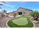 Lush backyard oasis with putting green, rock waterfall pool, and tropical palm trees for relaxation at 20102 E Robin Rd, Queen Creek, AZ 85142