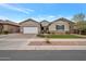 Well-maintained single-Gathering home featuring a lush green lawn, brick accents, and a spacious driveway at 20102 E Robin Rd, Queen Creek, AZ 85142