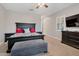 Well-lit bedroom with ceiling fan, tv and a large bed with dark wood furniture at 20102 E Robin Rd, Queen Creek, AZ 85142