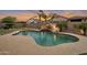 Backyard pool with water feature, rock slide, putting green, and lush landscaping at sunset at 20102 E Robin Rd, Queen Creek, AZ 85142