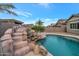 Backyard pool featuring a rock waterfall, tropical landscaping, and clear blue water at 20102 E Robin Rd, Queen Creek, AZ 85142