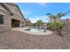 Backyard showcasing a sparkling pool, rock waterfall, and mature palm trees for a private escape at 20102 E Robin Rd, Queen Creek, AZ 85142