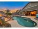 Backyard swimming pool with rock waterfall feature, lush landscaping and covered patio at 20102 E Robin Rd, Queen Creek, AZ 85142