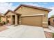 Low angle view of the attractive single-story home showcasing a two-car garage and covered entryway at 213 S 225Th Ln, Buckeye, AZ 85326