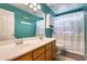 Bathroom with double sink vanity, large mirror, and teal walls at 23693 W La Vista Cir, Buckeye, AZ 85396