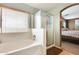 Bathroom featuring a soaking tub, glass shower and window with blinds at 23693 W La Vista Cir, Buckeye, AZ 85396