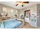 Bedroom features gray walls, ceiling fan, sliding door closet and built-in shelves at 23693 W La Vista Cir, Buckeye, AZ 85396