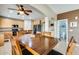 Open-concept dining area features a large table with seating for six and easy access to a nearby half-bath at 23693 W La Vista Cir, Buckeye, AZ 85396