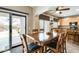 Bright dining area features sliding glass doors, and kitchen with tile backsplash and modern lighting fixtures at 23693 W La Vista Cir, Buckeye, AZ 85396