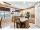 Bright kitchen featuring a center island with seating, natural wood cabinets, and modern appliances at 23693 W La Vista Cir, Buckeye, AZ 85396