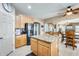 Open kitchen with an island, black appliances, and seamless flow to the dining and living areas at 23693 W La Vista Cir, Buckeye, AZ 85396