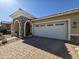 This single-story house features an attached two-car garage, a stone archway, and a tiled roof at 24986 N 172Nd Ln, Surprise, AZ 85387