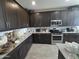 Large kitchen boasts stainless steel appliances, dark wood cabinets, light countertops, and tile flooring at 24986 N 172Nd Ln, Surprise, AZ 85387