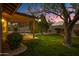 Inviting backyard at dusk with a covered patio and lush landscaping, perfect for evening relaxation at 3060 W Ironwood Cir, Chandler, AZ 85226