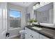 Bright bathroom featuring white cabinets, dark fixtures, and a large window providing natural light at 3060 W Ironwood Cir, Chandler, AZ 85226