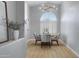 Cozy dining room with arched window, plantation shutters, modern chandelier, and a round wooden table at 3060 W Ironwood Cir, Chandler, AZ 85226