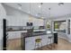 Modern kitchen with white cabinets, black countertop, and a center island with bar stools and a view to the pool at 3060 W Ironwood Cir, Chandler, AZ 85226