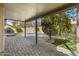 Spacious covered patio with stone pavers overlooks a lush backyard with a sparkling pool at 3060 W Ironwood Cir, Chandler, AZ 85226