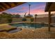 A private backyard pool features a rock waterfall and brick patio surrounded by lush landscaping at 3060 W Ironwood Cir, Chandler, AZ 85226