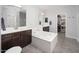 Well-lit bathroom with double vanity sinks, a soaking tub, and a separate walk-in closet at 3121 N Loma Vista Dr, Mesa, AZ 85213