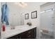 Bright bathroom with a dark vanity, white countertops, and a large mirror, with access to the toilet at 3121 N Loma Vista Dr, Mesa, AZ 85213