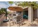 Outdoor patio features an outdoor kitchen with bar, a dining table with umbrella, and comfortable seating for entertaining at 3121 N Loma Vista Dr, Mesa, AZ 85213