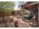 Inviting covered patio with comfortable seating, a built-in grill, and a lush, landscaped backyard at 3121 N Loma Vista Dr, Mesa, AZ 85213