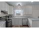 Well-lit kitchen boasts stainless steel appliances, white cabinetry, and updated fixtures at 345 N Madison St, Wickenburg, AZ 85390