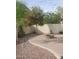 Outdoor oasis featuring mature trees, decorative rock landscaping, and a cozy fire pit area, perfect for entertaining or relaxing at 40232 W Marion May Ln, Maricopa, AZ 85138