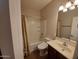 This full bathroom has shower with curtain, toilet, and sink with dark brown vanity at 40232 W Marion May Ln, Maricopa, AZ 85138