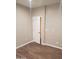 Bedroom featuring hardwood floors, neutral paint, and a bright, white door leading to an adjacent room at 40232 W Marion May Ln, Maricopa, AZ 85138