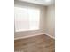 Bedroom with hardwood floors, featuring a bright window, base molding and neutral paint at 40232 W Marion May Ln, Maricopa, AZ 85138