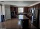 Spacious kitchen with stainless steel appliances, an island, and dark wood cabinetry at 40232 W Marion May Ln, Maricopa, AZ 85138