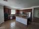 Kitchen featuring dark cabinets, stainless steel appliances, and a center island, with tiled floors at 40232 W Marion May Ln, Maricopa, AZ 85138