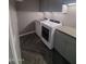 Laundry room featuring gray cabinets, herringbone tile, and stainless steel appliances at 40232 W Marion May Ln, Maricopa, AZ 85138