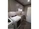 Modern laundry room with gray cabinets, updated countertops and herringbone floors at 40232 W Marion May Ln, Maricopa, AZ 85138