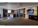 Open concept living room featuring a kitchen with dark wood cabinets and a stone accent wall at 40232 W Marion May Ln, Maricopa, AZ 85138