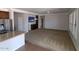 Bright living room featuring plush carpeting, flat screen TV and stainless steel refrigerator at 40232 W Marion May Ln, Maricopa, AZ 85138