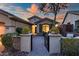 Charming home entrance featuring a decorative gate, manicured plants, and inviting walkway at 41006 N Noble Hawk Way, Anthem, AZ 85086