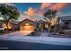 Charming home exterior with well-manicured desert landscaping, lighting, and a welcoming entrance at 41006 N Noble Hawk Way, Anthem, AZ 85086